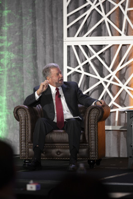 Corporate event photography, executive fireside chat interview on stage at business conference.