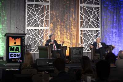 Corporate event photography, executive fireside chat interview on stage at business conference.