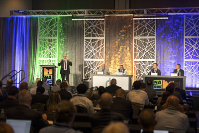 Corporate event photography, executive fireside chat interview on stage at business conference.