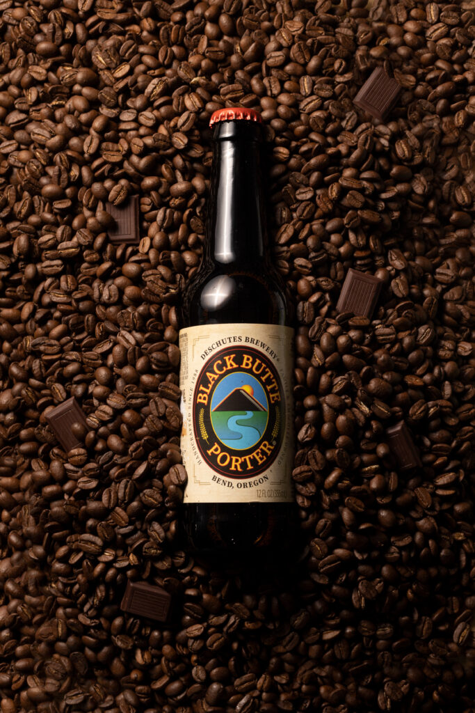 Houston product photographer, craft beer bottle photography for beverage marketing, Deschutes Black Butte Porter on coffee beans with chocolate.