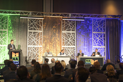 Corporate event photography, executive fireside chat interview on stage at business conference.