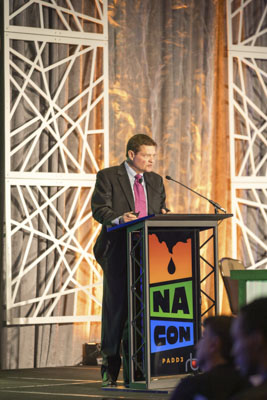 Keynote speaker at NA CON conference, executive presenting on stage at industry event.