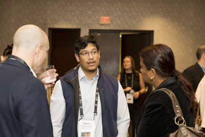 Corporate event networking, conference attendees connecting and talking during reception.