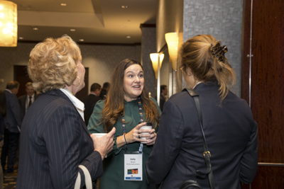 Corporate event networking, conference attendees connecting and talking during reception.