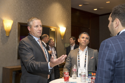 Corporate event networking, conference attendees connecting and talking during reception.